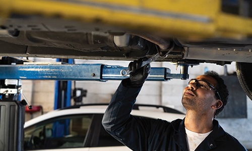 Mechanic working on a car in an auto shop.