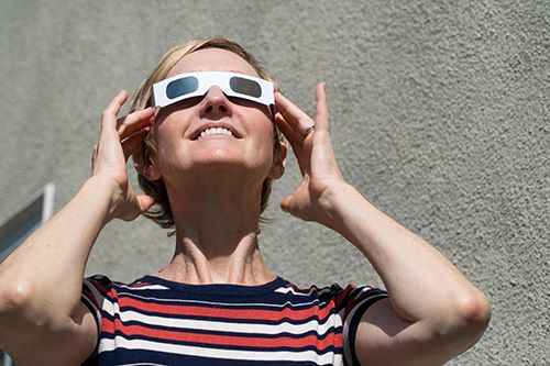 Woman viewing eclipse with eclipse glasses